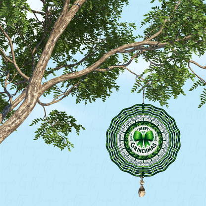 Decorative ornament with 'Merry Grinchmas' text hanging from a tree