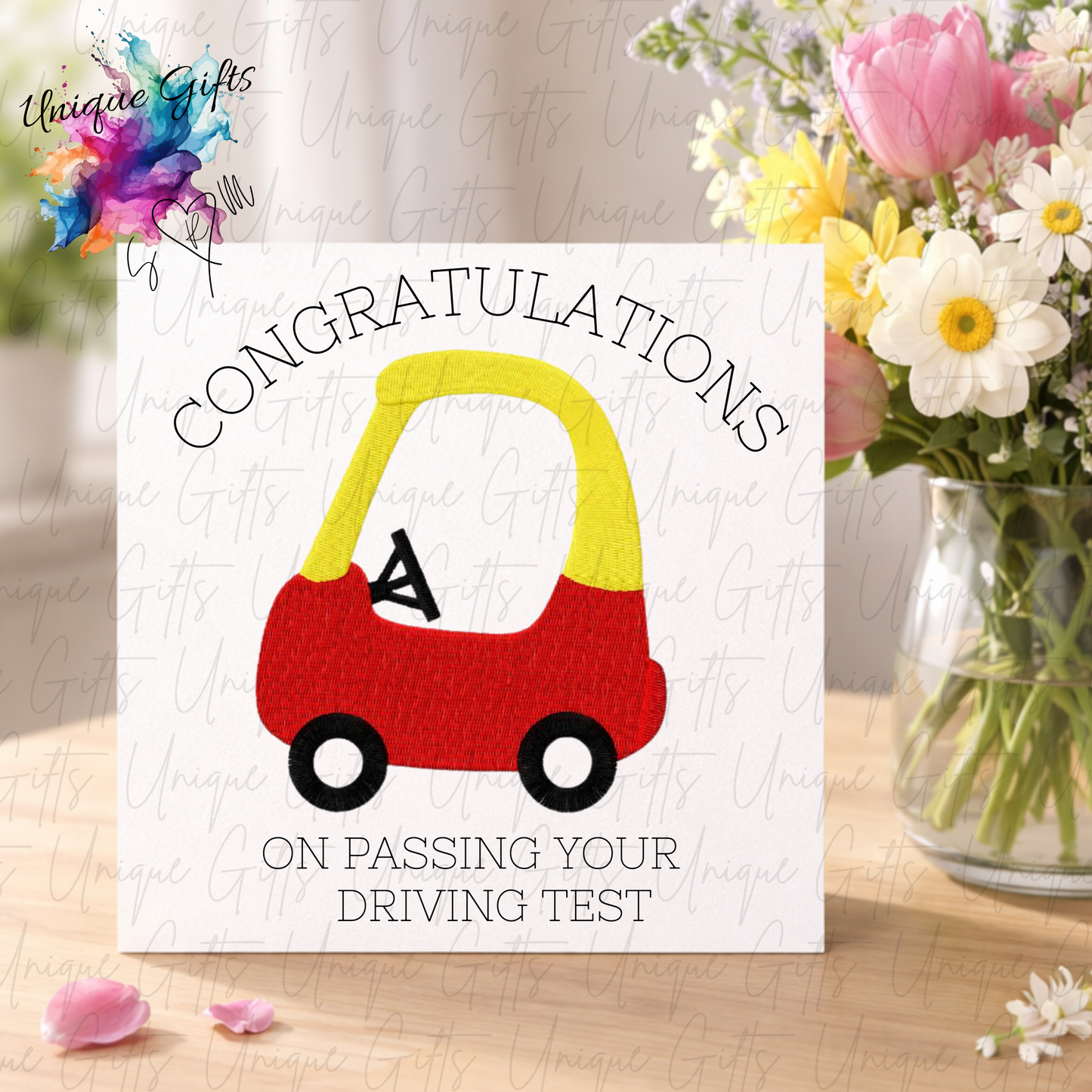 Driving test congratulations card displayed with flowers showing toy car design | Unique Gifts