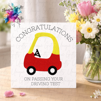 Driving test congratulations card displayed with flowers showing toy car design | Unique Gifts