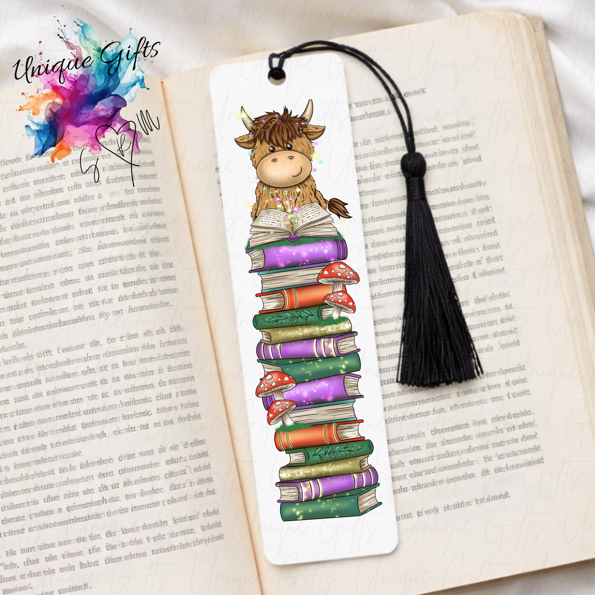 Personalised highland cow reading bookmark – cow with open book on book stack – aluminium with black tassel