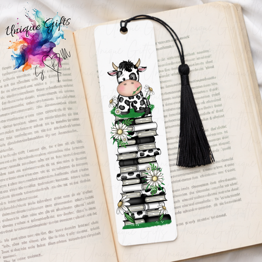 Personalised cow bookmark with daisies on book stack – countryside reading gift – aluminium with black tassel