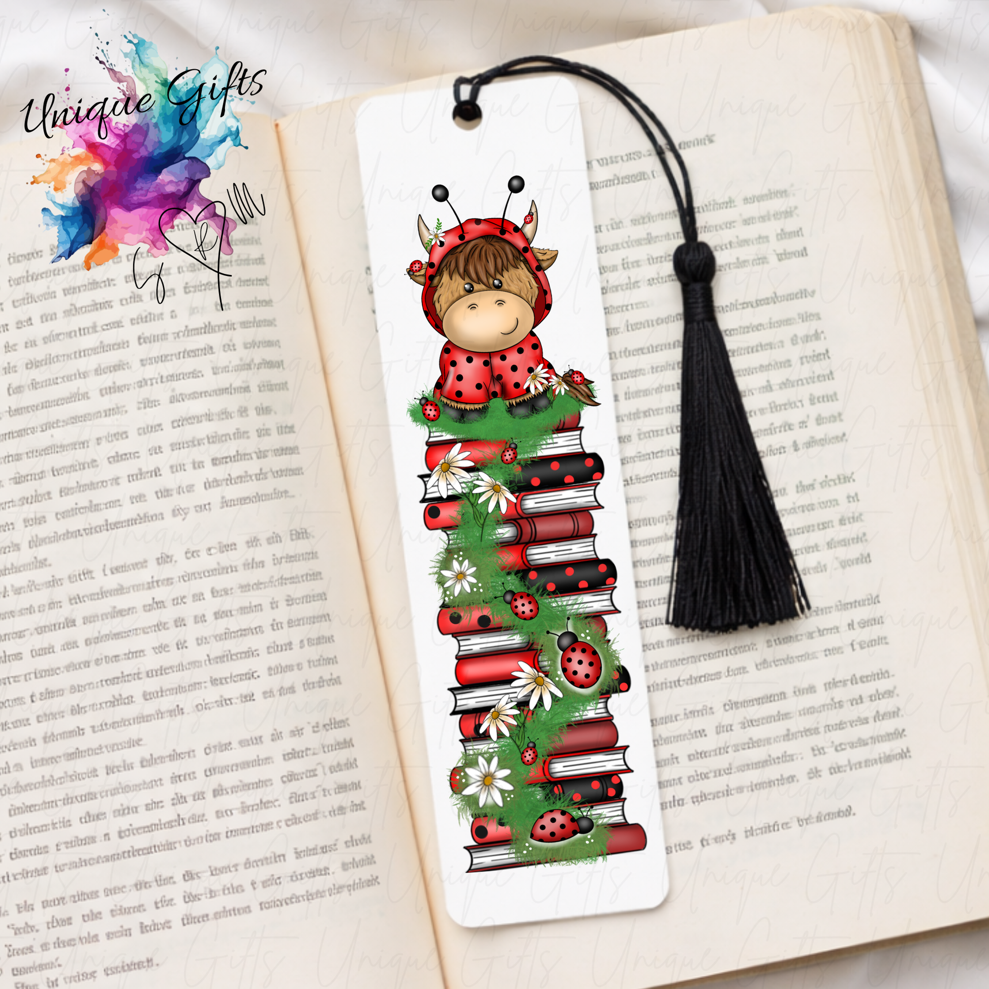 Personalised highland cow ladybird bookmark – cow in ladybird outfit on book stack – aluminium with black tassel