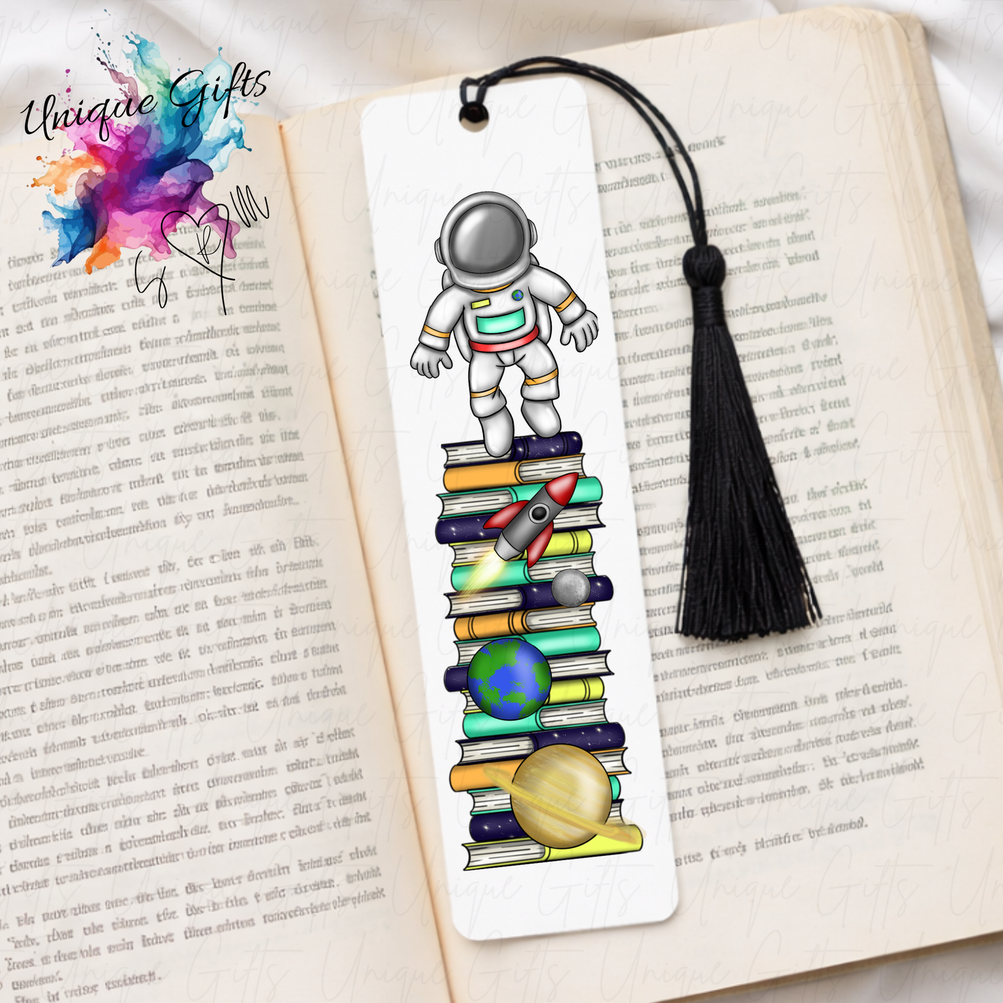Personalised space man bookmark with planets – cosmic book stack design – aluminium with black tassel